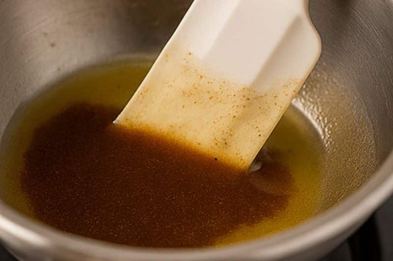 Melting beeswax and butter over a double boiler and blending in coffee oil for lip balm