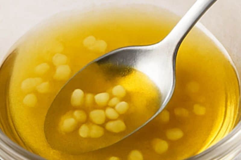 Melting beeswax with almond oil over a double boiler and mixing in turmeric for lip balm