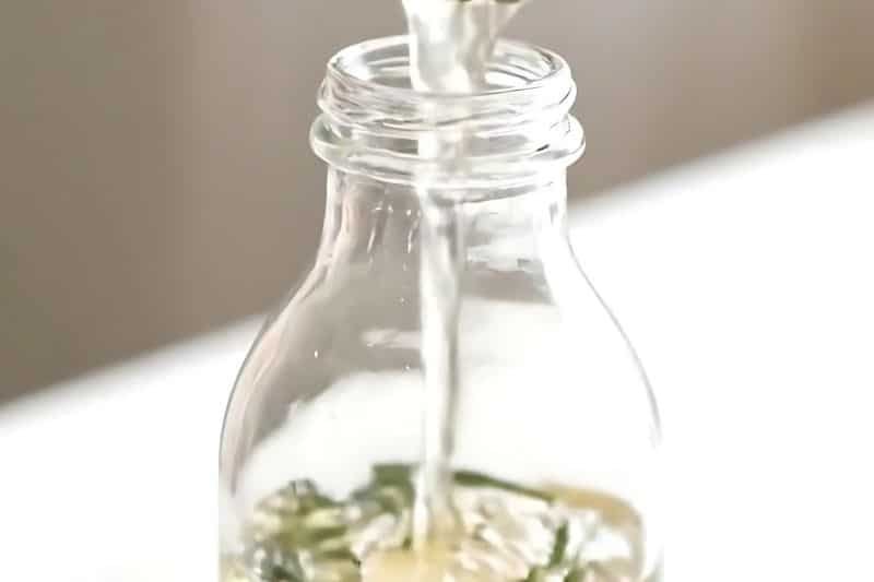 Simmering rosemary sprigs in a pot of water for DIY hair rinse